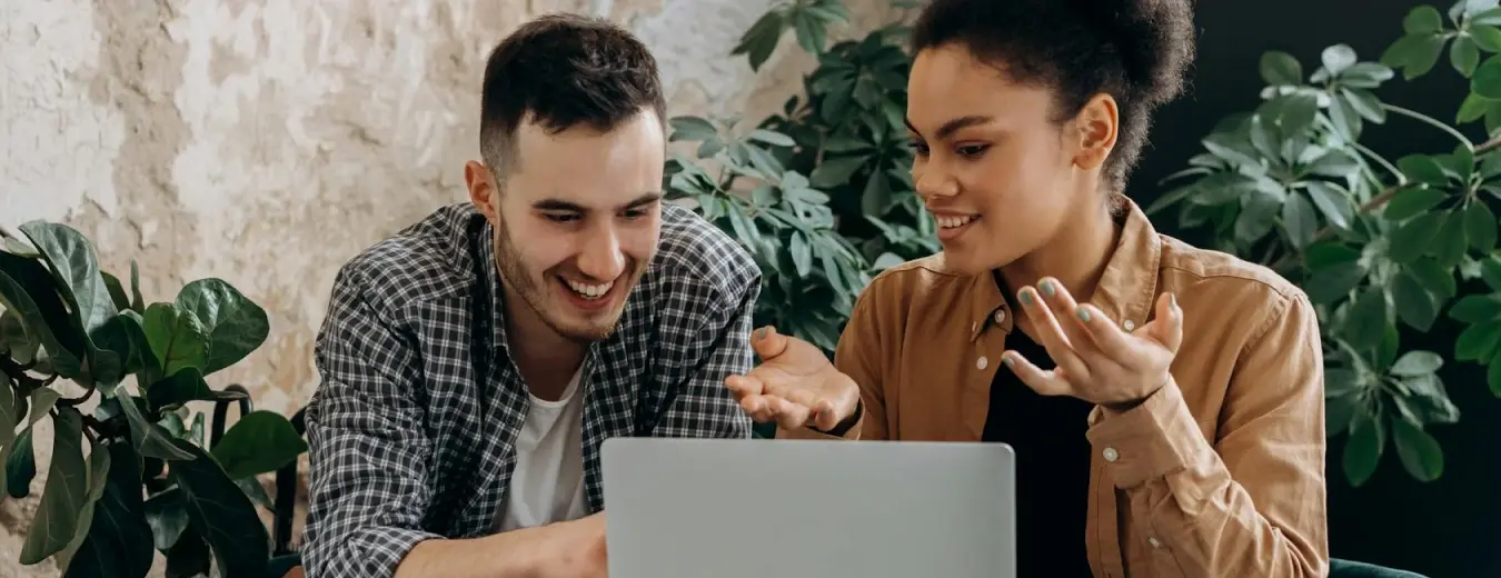 Two people picking something out on a laptop together