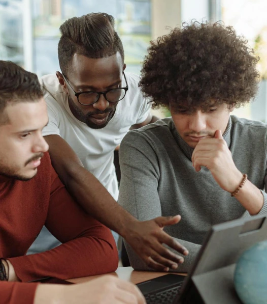 Three colleagues going over work on a laptop together