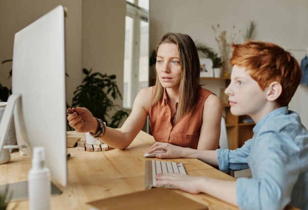Two people watching a build run on a screen at a desk